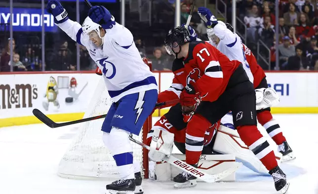 Tampa Bay Lightning center Brayden Point (21) celebrates after scoring a goal against New Jersey Devils goaltender Jake Allen (34) during the first period of a NHL hockey game, Tuesday Oct. 22, 2024, in Newark, N.J. (AP Photo/Noah K. Murray)