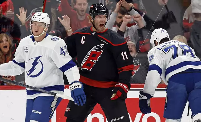 Carolina Hurricanes' Jordan Staal (11) celebrates after his goal between Tampa Bay Lightning's Darren Raddysh (43) and Emil Lilleberg (78) during the first period of an NHL hockey game in Raleigh, N.C., Friday, Oct. 11, 2024. (AP Photo/Karl B DeBlaker)