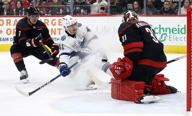 Tampa Bay Lightning's Mitchell Chaffee (41) has his shot blocked by Carolina Hurricanes goaltender Frederik Andersen (31) with Hurricanes' Dmitry Orlov (7) nearby during the first period of an NHL hockey game in Raleigh, N.C., Friday, Oct. 11, 2024. (AP Photo/Karl B DeBlaker)