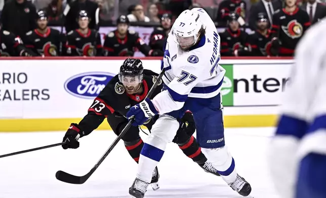 Tampa Bay Lightning defenceman Victor Hedman (77) shoots the puck as Ottawa Senators left wing Noah Gregor (73) defends, during first period NHL hockey action in Ottawa, on Saturday, Oct. 19, 2024. (Justin Tang/The Canadian Press via AP)