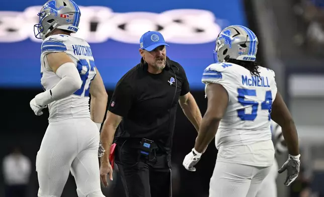 Detroit Lions head coach Dan Campbell, center, celebrates with Aidan Hutchinson (97) and Alim McNeill, right, after McNeill sacked Dallas Cowboys' Dak Prescott (4) in the first half of an NFL football game in Arlington, Texas, Sunday, Oct. 13, 2024. (AP Photo/Jerome Miron)