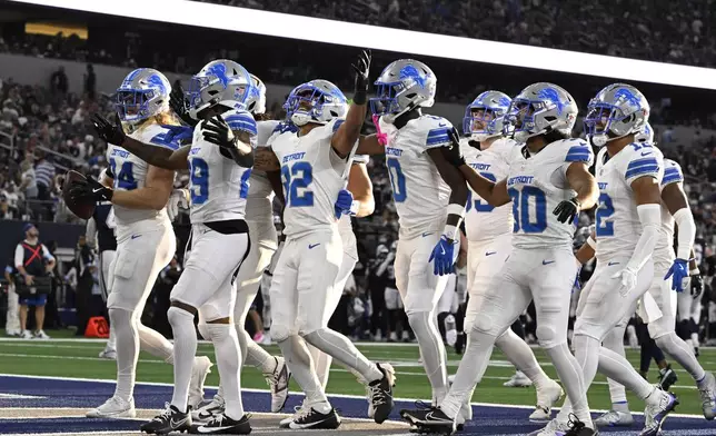 Detroit Lions' Brian Branch (32) celebrates with teammates afer Branch intercepted a pass thrown by Dallas Cowboys quarterback Dak Prescott (4) in the second half of an NFL football game in Arlington, Texas, Sunday, Oct. 13, 2024. (AP Photo/Jerome Miron)