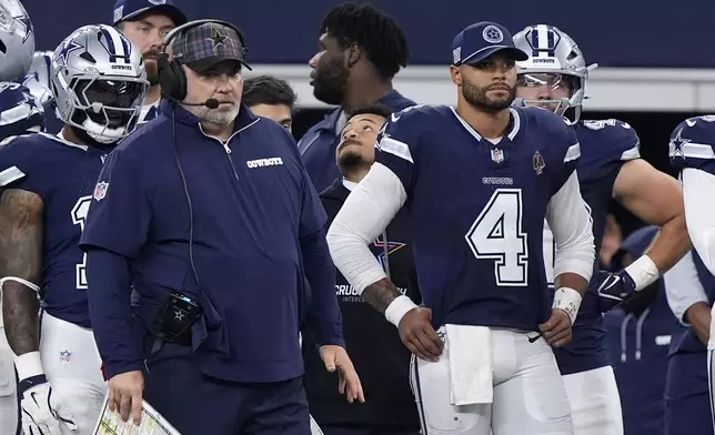 Dallas Cowboys head coach Mike McCarthy, left, and quarterback Dak Prescott (4) watch play against the Detroit Lions in the second half of an NFL football game in Arlington, Texas, Sunday, Oct. 13, 2024. (AP Photo/LM Otero)