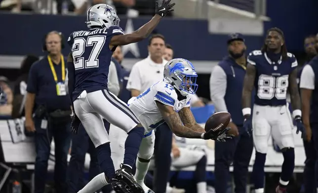 Detroit Lions wide receiver Tim Patrick (17) catches a long pass in front of Dallas Cowboys cornerback Amani Oruwariye (27) in the first half of an NFL football game in Arlington, Texas, Sunday, Oct. 13, 2024. (AP Photo/Jerome Miron)