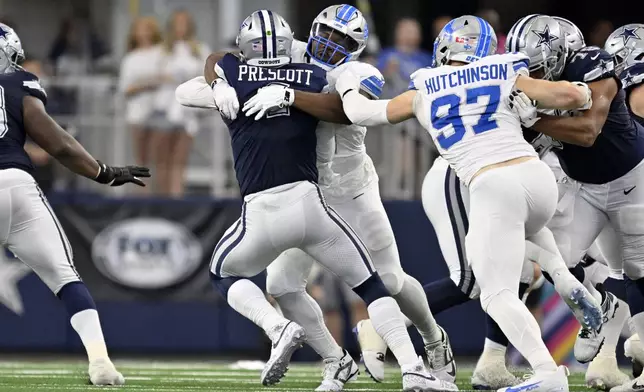 Dallas Cowboys quarterback Dak Prescott (4) is sacked by Detroit Lions defensive tackle Alim McNeill, rear, with pressure from Aidan Hutchinson (97) in the first half of an NFL football game in Arlington, Texas, Sunday, Oct. 13, 2024. (AP Photo/Jerome Miron)