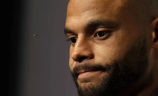 Dallas Cowboys quarterback Dak Prescott takes questions from reporters as a fly buzzes past during a news conference after an NFL football game against the Detroit Lions in Arlington, Texas, Sunday, Oct. 13, 2024. (AP Photo/Gareth Patterson)