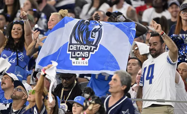 Fans hold up a Detroit Lions team flag that has a Mexico national flag colors on it in the second half of an NFL football game against the Dallas Cowboys in Arlington, Texas, Sunday, Oct. 13, 2024. (AP Photo/Jerome Miron)