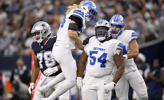 Detroit Lions' Alex Anzalone, left, Alim McNeill (54) and Malcolm Rodriguez (44) celebrate after Mcneill sacked Dallas Cowboys' Dak Prescott (4) in the first half of an NFL football game in Arlington, Texas, Sunday, Oct. 13, 2024. (AP Photo/Jerome Miron)