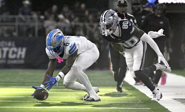 Detroit Lions cornerback Terrion Arnold (0) recovers a fumble by Dallas Cowboys wide receiver Ryan Flournoy (80) in the second half of an NFL football game in Arlington, Texas, Sunday, Oct. 13, 2024. (AP Photo/Jerome Miron)