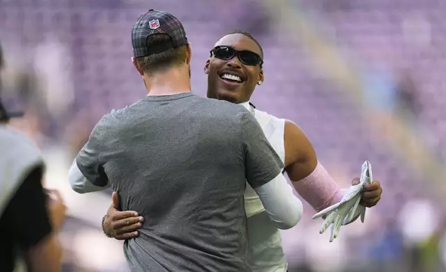 Minnesota Vikings quarterback Sam Darnold, left, and wide receiver Justin Jefferson hug before an NFL football game against the Detroit Lions Sunday, Oct. 20, 2024, in Minneapolis. (AP Photo/Abbie Parr)