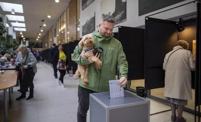 A voter casts his ballot during the advance voting in the first round of a parliamentary election in Vilnius, Lithuania, Wednesday, Oct. 9, 2024. (AP Photo/Mindaugas Kulbis)