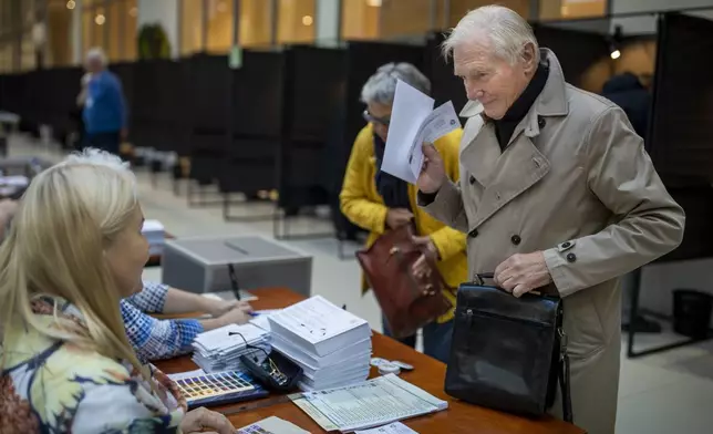 A man arrives at a polling station during the advance voting in the first round of a parliamentary election in Vilnius, Lithuania, Wednesday, Oct. 9, 2024. (AP Photo/Mindaugas Kulbis)