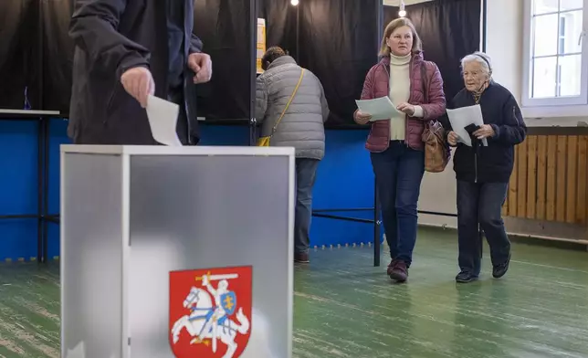 Residents cast their ballots at a polling station during the first round of voting in presidential elections in Vilnius, Lithuania, Sunday, Oct. 13, 2024. (AP Photo/Mindaugas Kulbis)