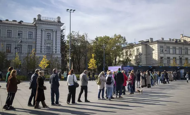 Voters queue at the polling station during the advance voting in the first round of a parliamentary election in Vilnius, Lithuania, Wednesday, Oct. 9, 2024. (AP Photo/Mindaugas Kulbis)