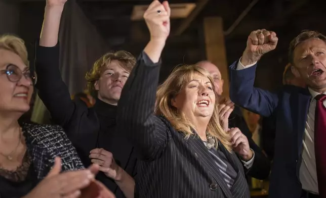 Leader of the Social Democratic Party Vilija Blinkeviciute, center, celebrates winning the first round of Lithuania's parliamentary election, in Vilnius, Lithuania, Sunday, Oct. 13, 2024. (AP Photo/Mindaugas Kulbis)