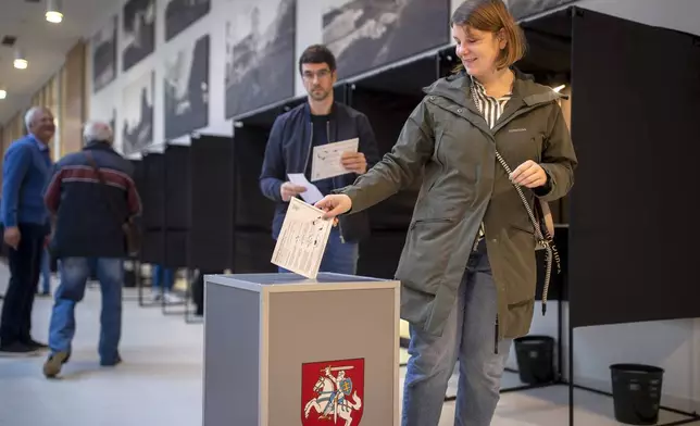 A voter casts his ballot during the advance voting in the first round of a parliamentary election in Vilnius, Lithuania, Wednesday, Oct. 9, 2024. (AP Photo/Mindaugas Kulbis)