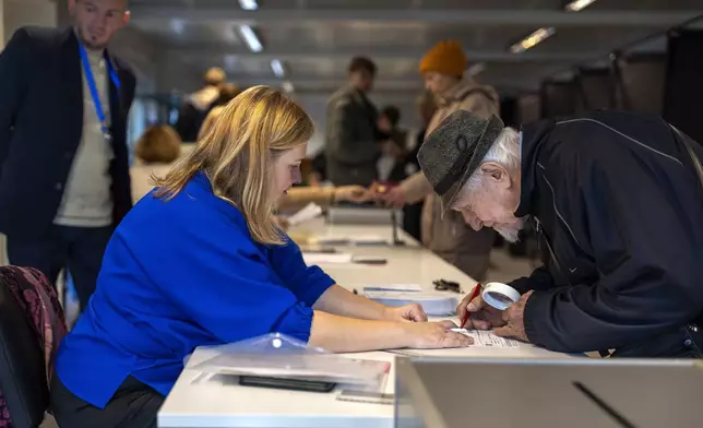 A local resident arrives at a polling station during the advance voting in the second round of a parliamentary election in Vilnius, Lithuania, Tuesday, Oct. 22, 2024. (AP Photo/Mindaugas Kulbis)