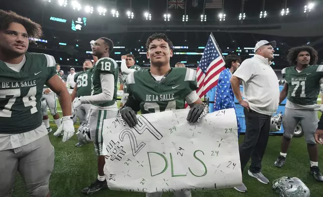 De La Salle running back Duece Jones-Drew, center, smiles to his supporters after a football game between the NFL Academy team and De La Salle High School, Tuesday, Oct. 8, 2024, in London. (AP Photo/Kin Cheung)