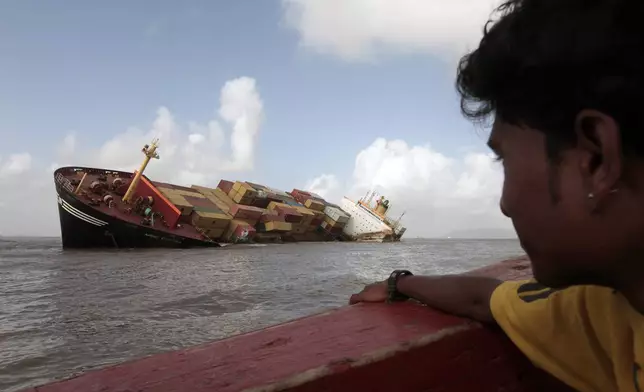 FILE - A man looks at the Panamanian-registered container ship MSC Chitra that days earlier collided with the MV-Khalijia-II, a St. Kitts registered ship, in the Arabian Sea near Mumbai, India, Tuesday, Aug. 10, 2010. (AP Photo/Rajanish Kakade, File)