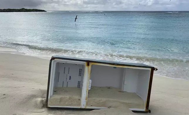 This March 30, 2021, photo provided by Jon Brack and the Friends of Midway Atoll shows a refrigerator which washed up on the shore of Midway Atoll, a national wildlife refuge for millions of seabirds near the Hawaiian Islands in the Pacific Ocean. (Jon Brack, Friends of Midway Atoll via AP)