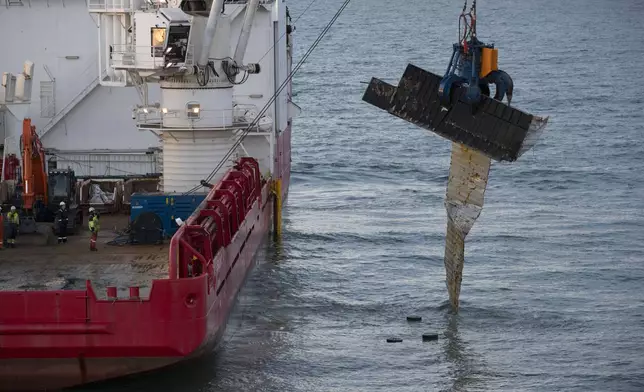 FILE - The Geosund salvaging ship lifts a container from the seabed off the northwestern coast of the Netherlands on Monday, Jan. 21, 2019, after the MSC Zoe freighter was caught in a heavy storm earlier in the month. (AP Photo/Peter Dejong, File)