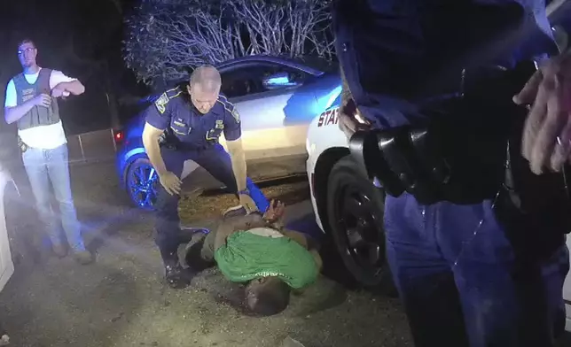 FILE — This image from video from Louisiana state trooper Lt. John Clary's body-worn camera shows trooper Kory York standing over Ronald Greene on his stomach on May 10, 2019, outside of Monroe, La. (Lt. John Clary/Louisiana State Police via AP, File)