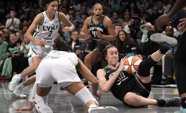 New York Liberty's Breanna Stewart, right, and Minnesota Lynx's Napheesa Collier, front left, fight for the ball during the second half in Game 2 of a WNBA basketball final playoff series, Sunday, Oct. 13, 2024, in New York. (AP Photo/Pamela Smith)