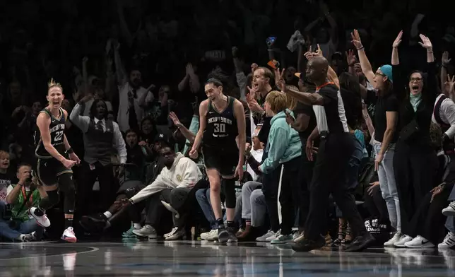 New York Liberty's Courtney Vandersloot (22) and Breanna Stewart (30) react after Steward scored a 3-point basket during the second half in Game 2 of a WNBA basketball final playoff series against the Minnesota Lynx, Sunday, Oct. 13, 2024, in New York. (AP Photo/Pamela Smith)