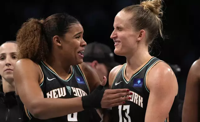 New York Liberty's Nyara Sabally, front left, and Leonie Fiebich, right, react after defeating the Minnesota Lynx in Game 2 of a WNBA basketball final playoff series, Sunday, Oct. 13, 2024, in New York. (AP Photo/Pamela Smith)