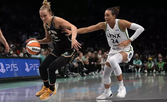 New York Liberty's Leonie Fiebich, left, dribbles against Minnesota Lynx's Napheesa Collier, right, during the first half in Game 2 of a WNBA basketball final playoff series, Sunday, Oct. 13, 2024, in New York. (AP Photo/Pamela Smith)