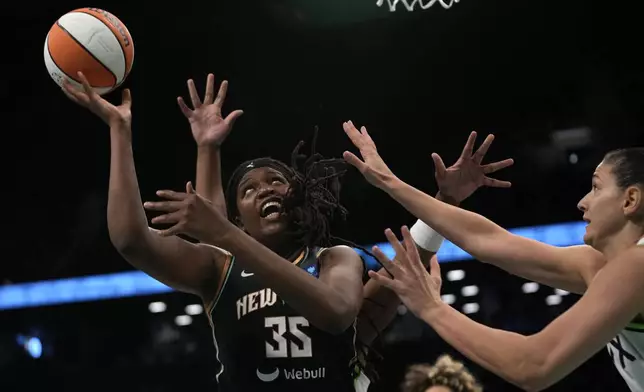 New York Liberty's Jonquel Jones, left, attempts to score during the first half in Game 2 of a WNBA basketball final playoff series against the Minnesota Lynx, Sunday, Oct. 13, 2024, in New York. (AP Photo/Pamela Smith)