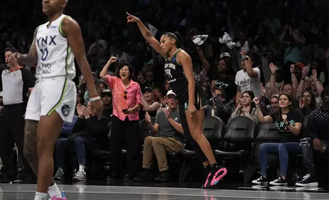 New York Liberty's Betnijah Laney-Hamilton, front right, reacts after shooting a 3-point basket during the first half in Game 2 of a WNBA basketball final playoff series against the Minnesota Lynx, Sunday, Oct. 13, 2024, in New York. (AP Photo/Pamela Smith)