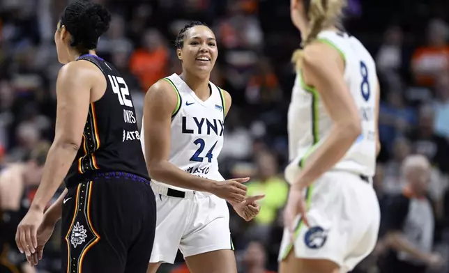 Minnesota Lynx forward Napheesa Collier (24) smiles at forward Alanna Smith (8) during the second half of a WNBA basketball semifinal game against the Connecticut Sun, Friday, Oct. 4, 2024, in Uncasville, Conn. (AP Photo/Jessica Hill)