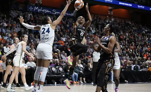 Connecticut Sun guard DiJonai Carrington (21) shoots over Minnesota Lynx forward Napheesa Collier (24) during the second half of a WNBA basketball semifinal game, Friday, Oct. 4, 2024, in Uncasville, Conn. (AP Photo/Jessica Hill)