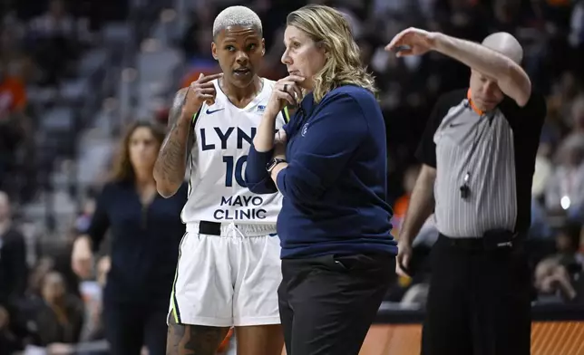 Minnesota Lynx guard Courtney Williams (10) talks with Minnesota Lynx head coach Cheryl Reeve, center, during the first half of a WNBA basketball semifinal game against the Connecticut Sun, Friday, Oct. 4, 2024, in Uncasville, Conn. (AP Photo/Jessica Hill)