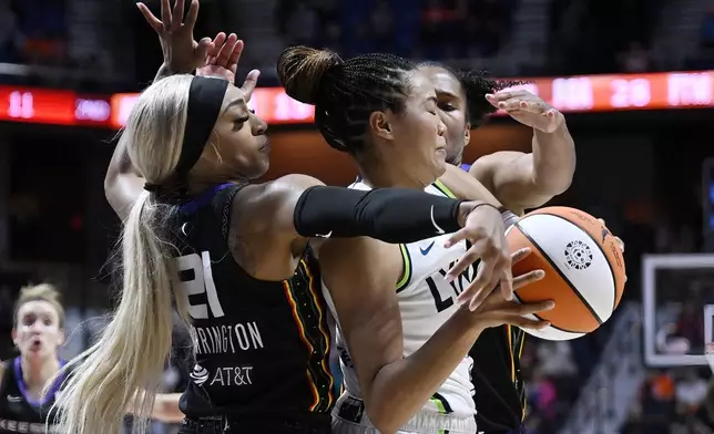 Connecticut Sun guard DiJonai Carrington, left, and Connecticut Sun forward Alyssa Thomas, right, pressure Minnesota Lynx forward Napheesa Collier during the first half of Game 4 in the WNBA basketball semifinals, Sunday, Oct. 6, 2024, in Uncasville, Conn. (AP Photo/Jessica Hill)