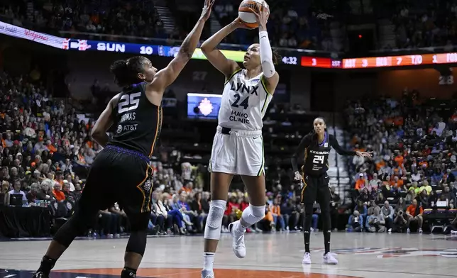 Minnesota Lynx forward Napheesa Collier (24) shoots over Connecticut Sun forward Alyssa Thomas (25) during the first half of a WNBA basketball semifinal game, Friday, Oct. 4, 2024, in Uncasville, Conn. (AP Photo/Jessica Hill)