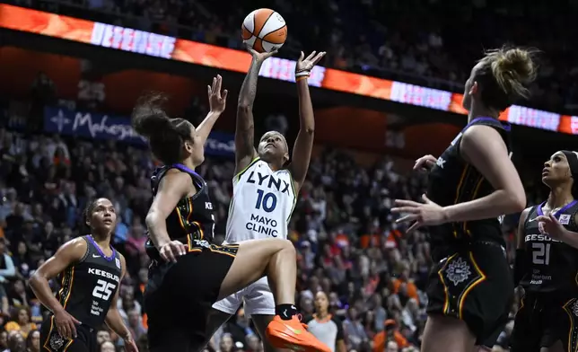 Minnesota Lynx guard Courtney Williams (10) shoots over Connecticut Sun guard Veronica Burton during the first half of a WNBA basketball semifinal game, Friday, Oct. 4, 2024, in Uncasville, Conn. (AP Photo/Jessica Hill)