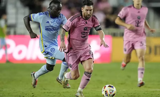 Atlanta United midfielder Tristan Muyumba (8) and Inter Miami forward Lionel Messi (10) go after the ball during the second half of of their MLS playoff opening round soccer match, Friday, Oct. 25, 2024, in Fort Lauderdale, Fla. (AP Photo/Rebecca Blackwell)