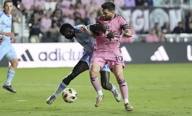 Atlanta United forward Jamal Thiaré (29) and Inter Miami forward Lionel Messi (10) go after the ball during the first half of match one of their MLS playoff opening round soccer match, Friday, Oct. 25, 2024, in Fort Lauderdale, Fla. (AP Photo/Rebecca Blackwell)