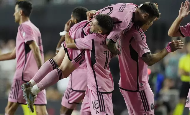 Inter Miami defender Jordi Alba (18) lifts Inter Miami forward Lionel Messi (10) after Alba scored a goal during the second half of match one of their MLS playoff opening round soccer match against Atlanta United, Friday, Oct. 25, 2024, in Fort Lauderdale, Fla. (AP Photo/Rebecca Blackwell)