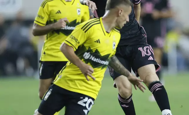 Inter Miami's Lionel Messi, right, dribbles the ball against Columbus Crew's Alexandru Matan during the first half of an MLS soccer match, Wednesday, Oct. 2, 2024, in Columbus, Ohio. (AP Photo/Jay LaPrete)