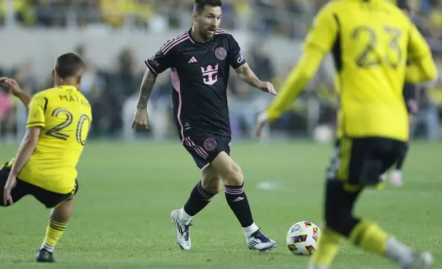 Inter Miami's Lionel Messi, center, tries to dribble between Columbus Crew's Alexandru Matan, left, and Mohamed Farsi during the first half of an MLS soccer match, Wednesday, Oct. 2, 2024, in Columbus, Ohio. (AP Photo/Jay LaPrete)