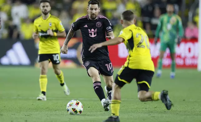 Inter Miami's Lionel Messi dribbles the ball as Columbus Crew's Alexandru Matan defends during the first half of an MLS soccer match Wednesday, Oct. 2, 2024, in Columbus, Ohio. (AP Photo/Jay LaPrete)