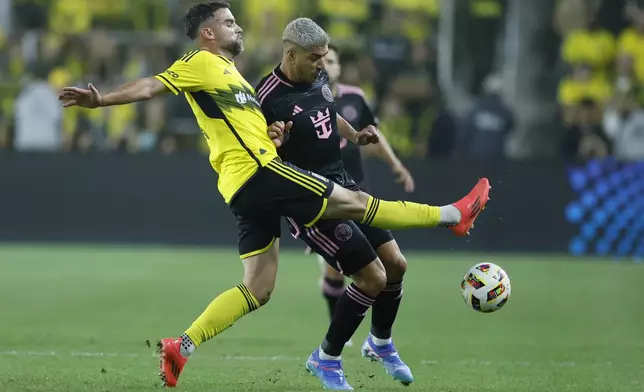 Columbus Crew's Rudy Camacho, left, kicks the ball past Inter Miami's Luis Suarez during the first half of an MLS soccer match Wednesday, Oct. 2, 2024, in Columbus, Ohio. (AP Photo/Jay LaPrete)