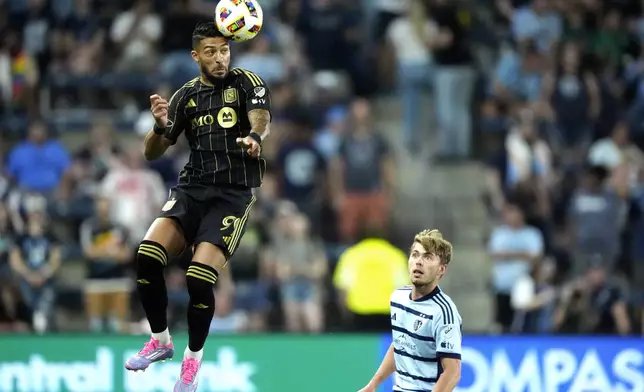 Los Angeles FC attacker Denis Bouanga, left, passes the ball over Sporting Kansas City defender Jake Davis during the first half of an MLS soccer match Saturday, Oct. 5, 2024, in Kansas City, Kan. (AP Photo/Charlie Riedel)