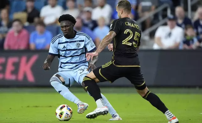 Sporting Kansas City attacker Stephen Afrifa (30) and Los Angeles FC defender Maxime Chanot (25) chase after the ball during the first half of an MLS soccer match Saturday, Oct. 5, 2024, in Kansas City, Kan. (AP Photo/Charlie Riedel)