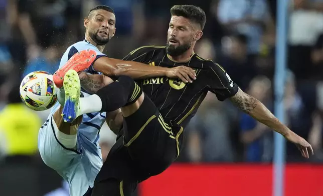 Sporting Kansas City defender Joaquin Fernandez, left, and Los Angeles FC attacker Olivier Giroud (9) battle for the ball during the first half of an MLS soccer match Saturday, Oct. 5, 2024, in Kansas City, Kan. (AP Photo/Charlie Riedel)