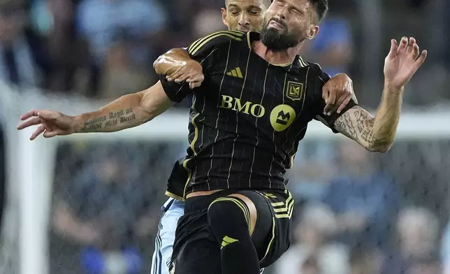 Sporting Kansas City defender Joaquin Fernandez, back, and Los Angeles FC attacker Olivier Giroud battle for the ball during the first half of an MLS soccer match Saturday, Oct. 5, 2024, in Kansas City, Kan. (AP Photo/Charlie Riedel)