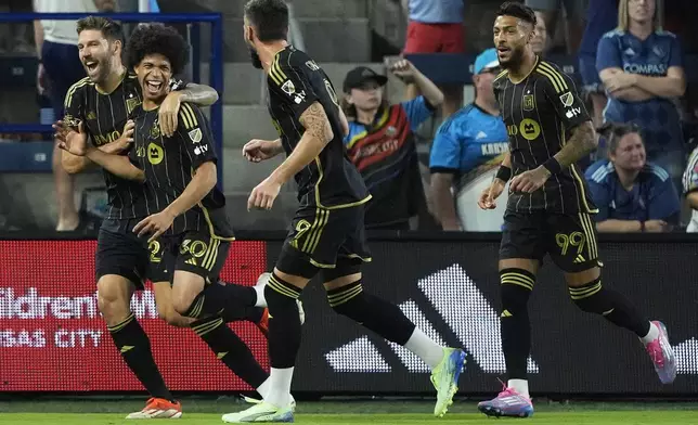 Los Angeles FC attacker David Martínez (30) celebrates with teammates after scoring a goal during the first half of an MLS soccer match against Sporting Kansas City Saturday, Oct. 5, 2024, in Kansas City, Kan. (AP Photo/Charlie Riedel)